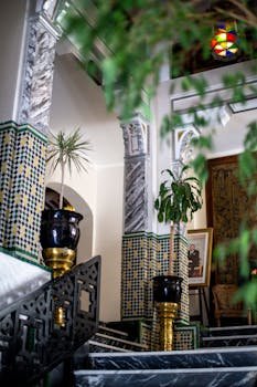 Explore a luxurious Moroccan interior with intricate tile work and lush plants.